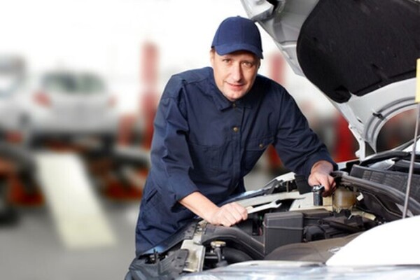 Car mechanic working in auto repair service.